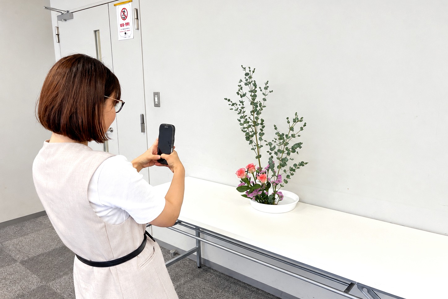 完成したいけばな作品をスマートフォンで撮影する参加者